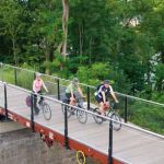 Drei Radfahrer auf einer Waggonbrücke am Panoramaradweg Niederbergbahn